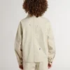 Beigefarbene Kinderjacke mit bunten Farbtupfern