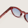 Cameron Panthos Sonnenbrille mit honigfarbenem Rahmen, Edelsteinen und blauen Gläsern
