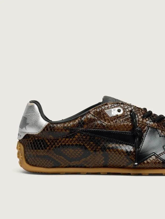Damen-Modell „Marathon Speed“ aus Leder mit braunem Schlangenprint, schwarzem Stern und silberner Lederlasche an der Ferse