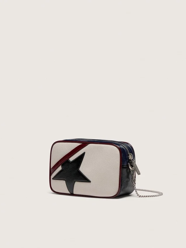 Mini Star Bag aus butterweißem Leder mit schwarzem Stern und burgunderroten sowie dunkelblauen Details