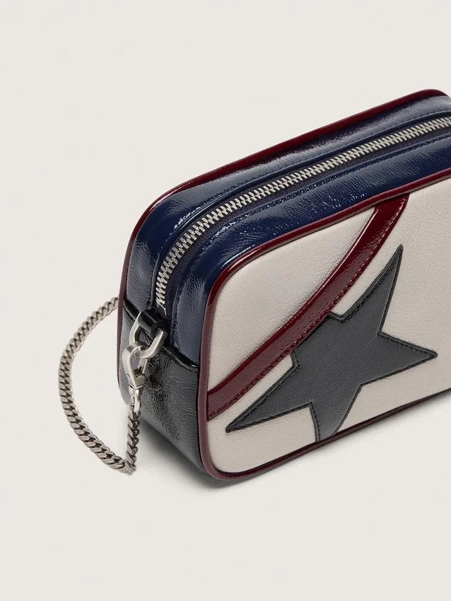 Mini Star Bag aus butterweißem Leder mit schwarzem Stern und burgunderroten sowie dunkelblauen Details