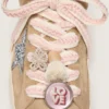 Schnürsenkel aus Lederwaren in Hellbeige mit rosa Zierband, Anstecknadel und Applikationen